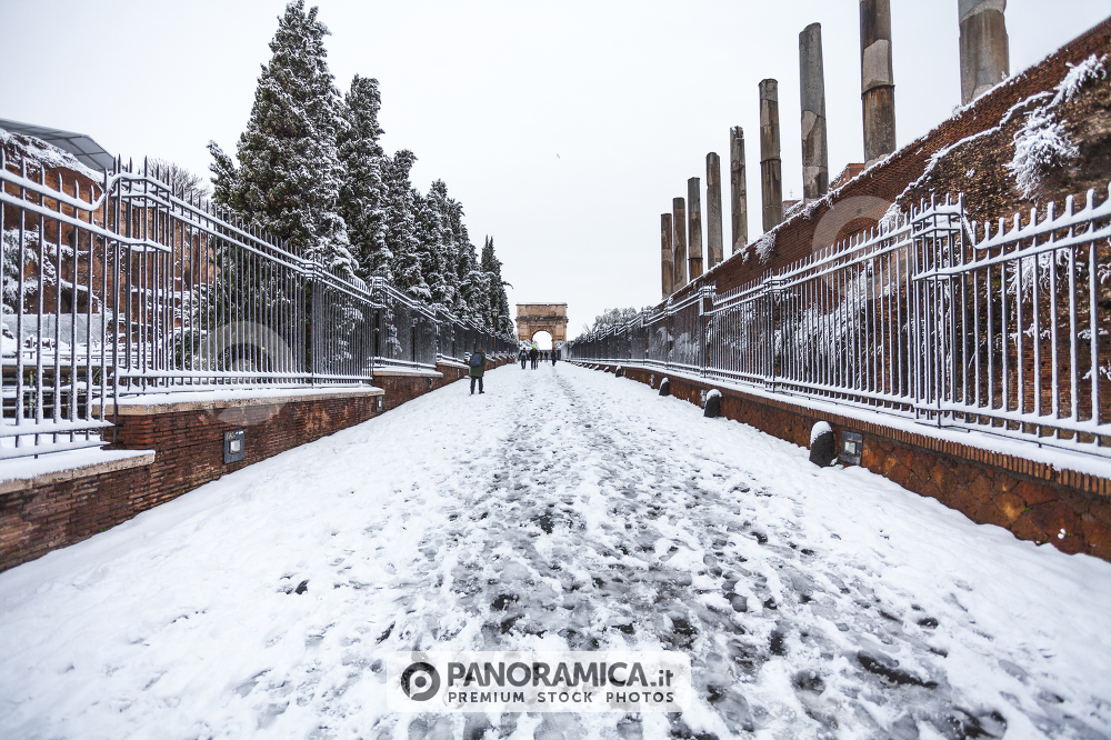 A lovely day of snow in Rome, Italy, 26th February 2018: a beautiful view of Via Sacra and Arch of Tito near Colosseum under the snow