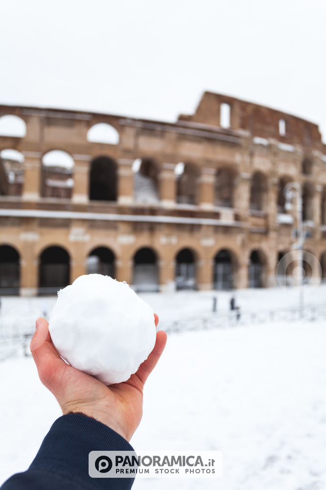 A lovely day of snow in Rome, Italy, 26th February 2018: a view of a snowball in my hand behind the Colosseum under the snow