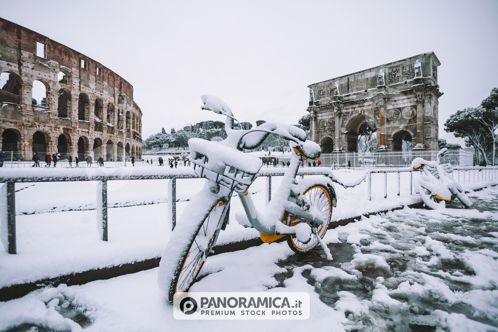 A lovely day of snow in Rome, Italy, 26th February 2018: a view of snowy bikes behind the Colosseum