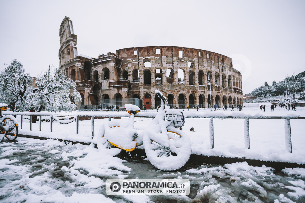 A lovely day of snow in Rome, Italy, 26th February 2018: a view of snowy bikes behind the Colosseum