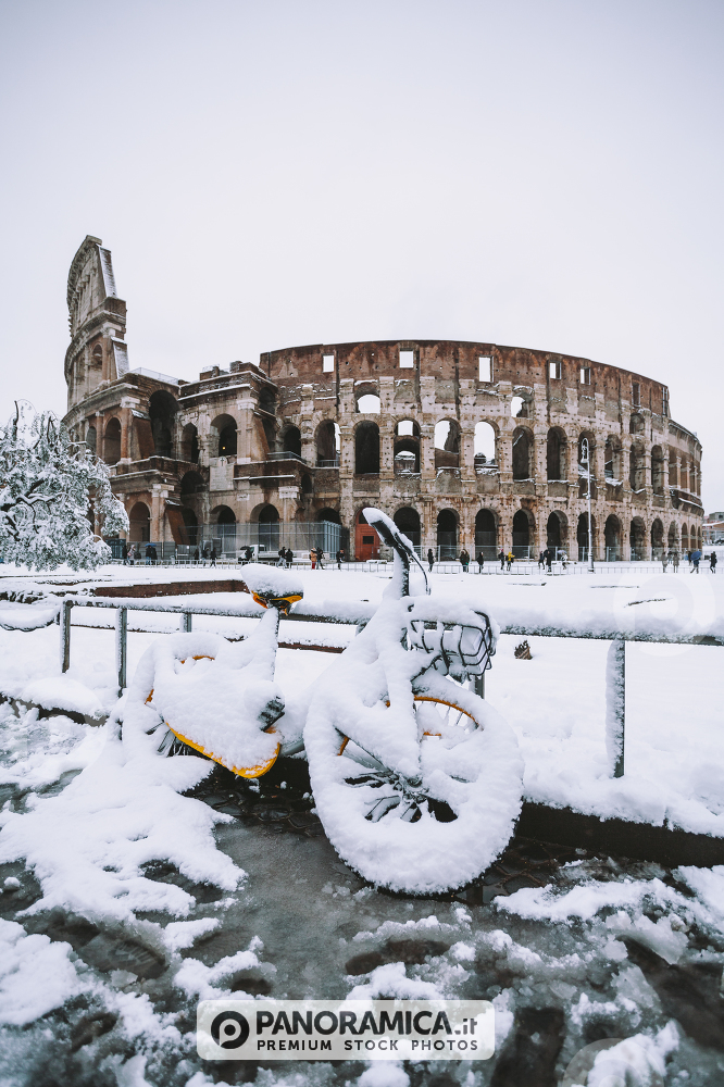A lovely day of snow in Rome, Italy, 26th February 2018: a view of snowy bikes behind the Colosseum