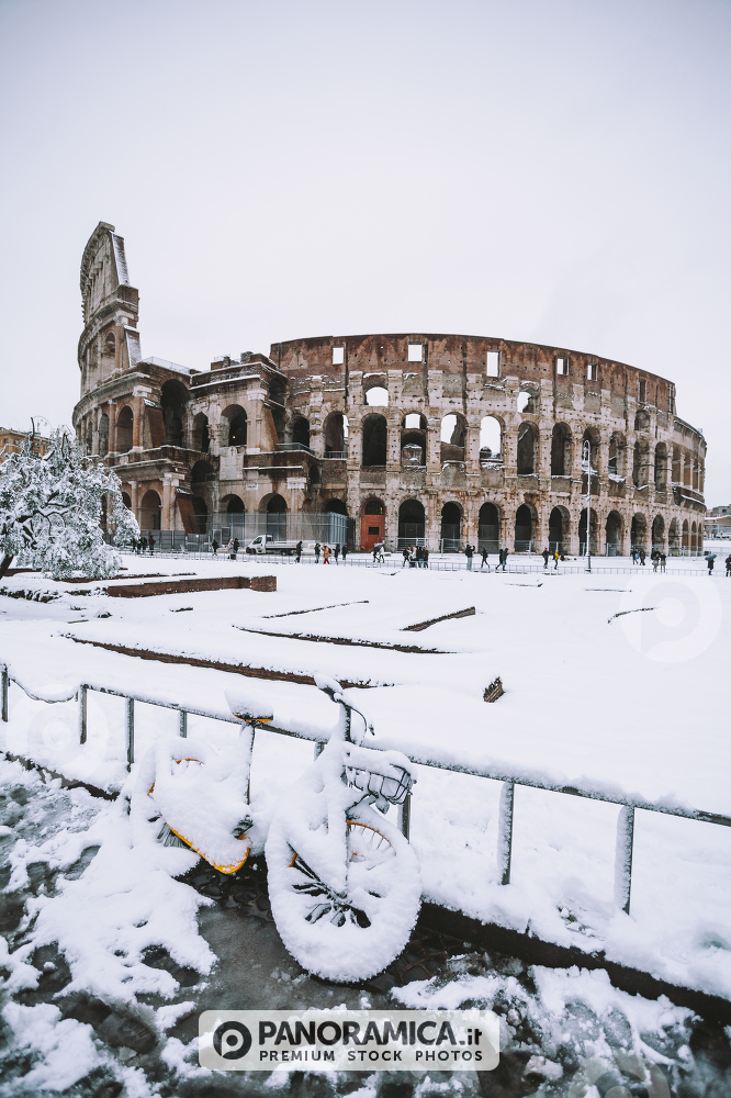 A lovely day of snow in Rome, Italy, 26th February 2018: a view of snowy bikes behind the Colosseum