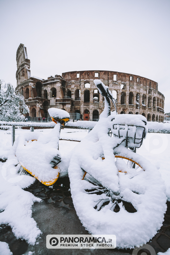 A lovely day of snow in Rome, Italy, 26th February 2018: a view of snowy bikes behind the Colosseum