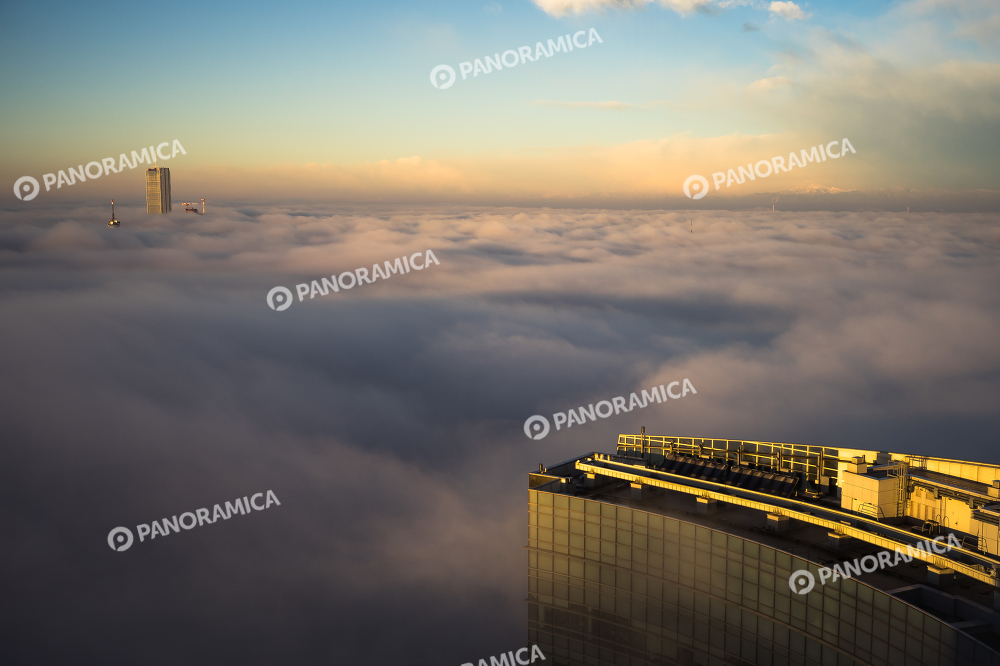 La Torre Allianz sbuca tra le nuvole all'alba