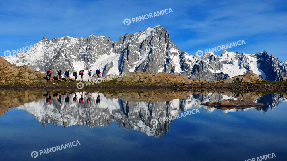 Trekkers con il Monte Bianco specchiato sul lago