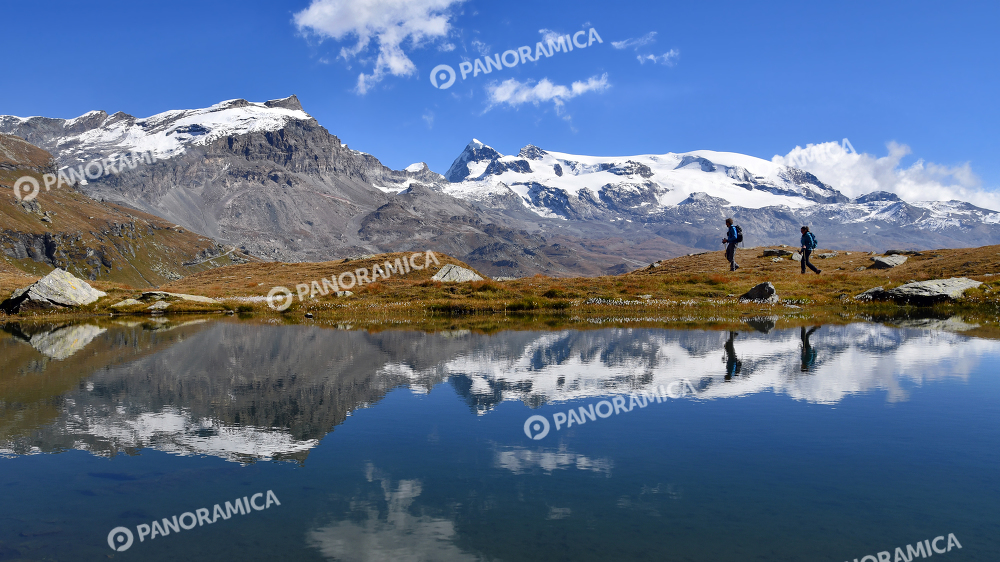 Trekkers e Monte Rosa riflessi sula lago.